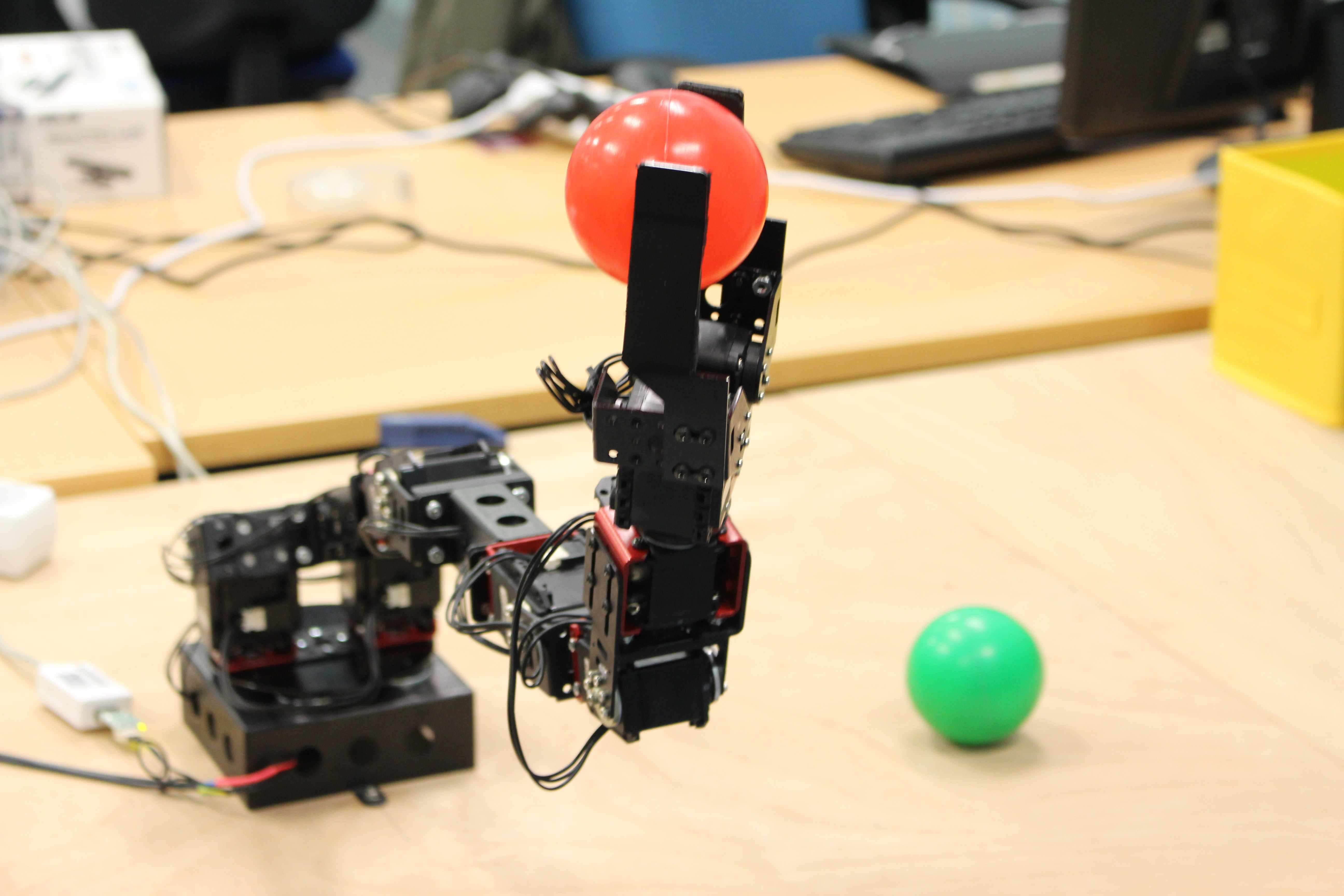 This robotic arm can learn simple object manipulations, like picking up plastic balls. Image courtesy of the DREAM consortium