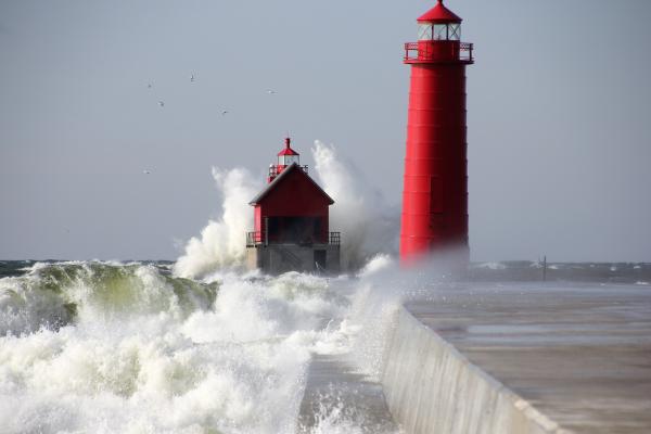 Ocean waves crashing against a lighthouse. 