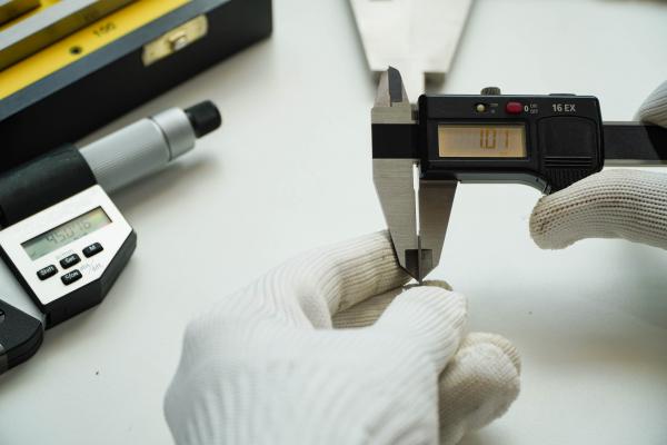 Fine measurement calipers in the hands of a scientist.