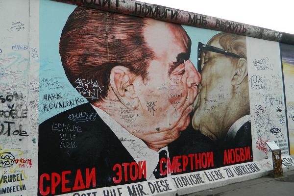The 'Fraternal Kiss' mural, by Soviet artist Dmitri Vrubel, emblematic of the Cold War, appeared on the Berlin East Side Gallery, Berlin Wall, 1990. Image credit - Freepenguin, licensed under CC BY-SA 3.0